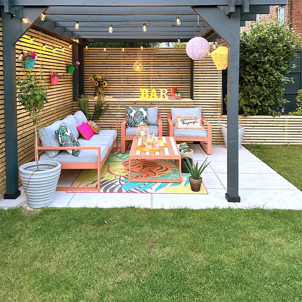 Beige porcelain patio slabs with lounge furniture and a pergola